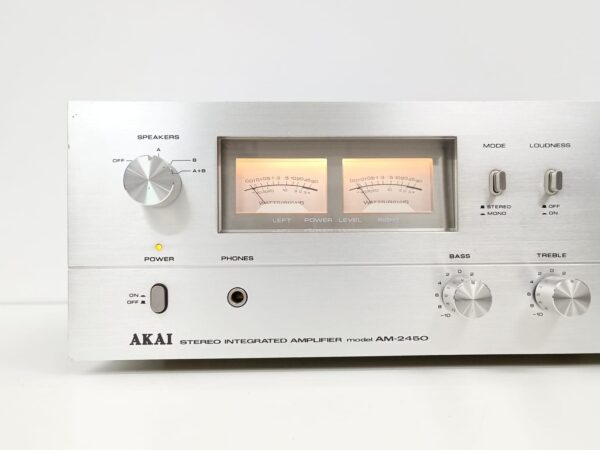 Primer plano de los controles y vúmetros luminosos del AKAI AM-2450 resaltando su estética vintage.